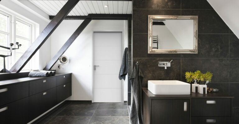 Bathroom in conjunction with bedroom. Structural beams, dark wood and granite tiles.